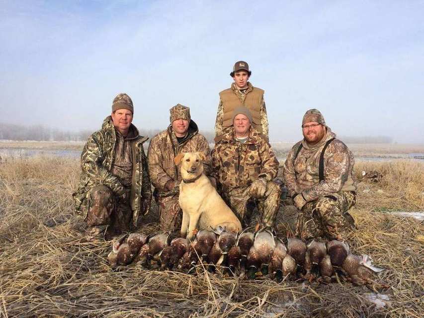 Saskatchewan duck hunt group photo with a yellow Labrador retriever Saskatchewan duck hunt group photo with a yellow Labrador retriever